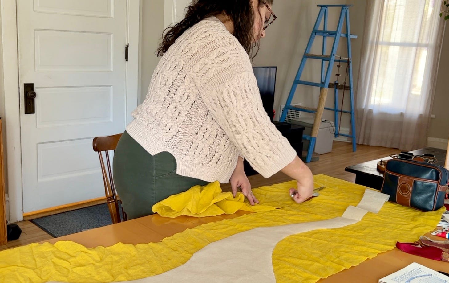 Cutting out a large piece of yellow linen