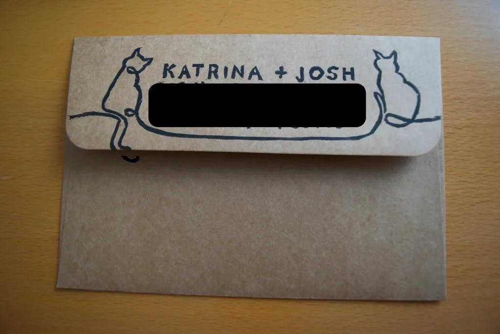 Completed stamped envelope with the return address stamp on the back flap. The address is blacked out.