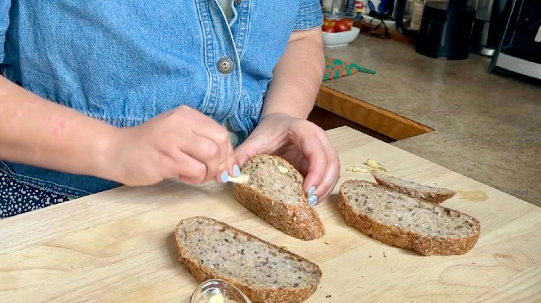 Rubbing garlic cloves on the bread slices
