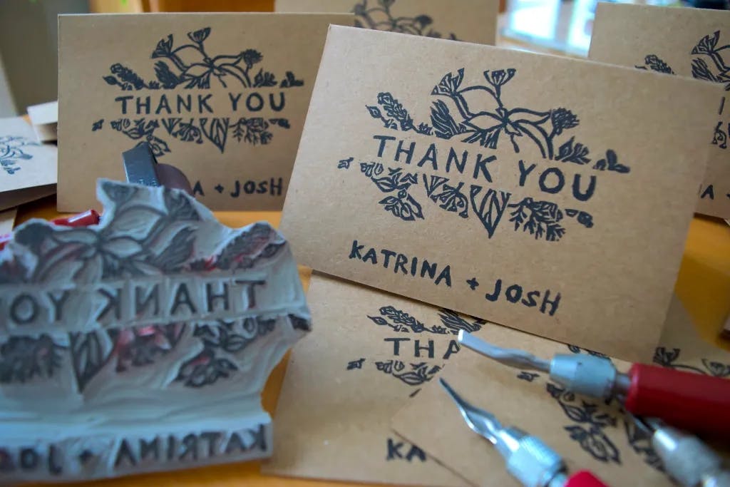 A still life of multiple printed cards, the carving knives, and the "thank you" stamp.