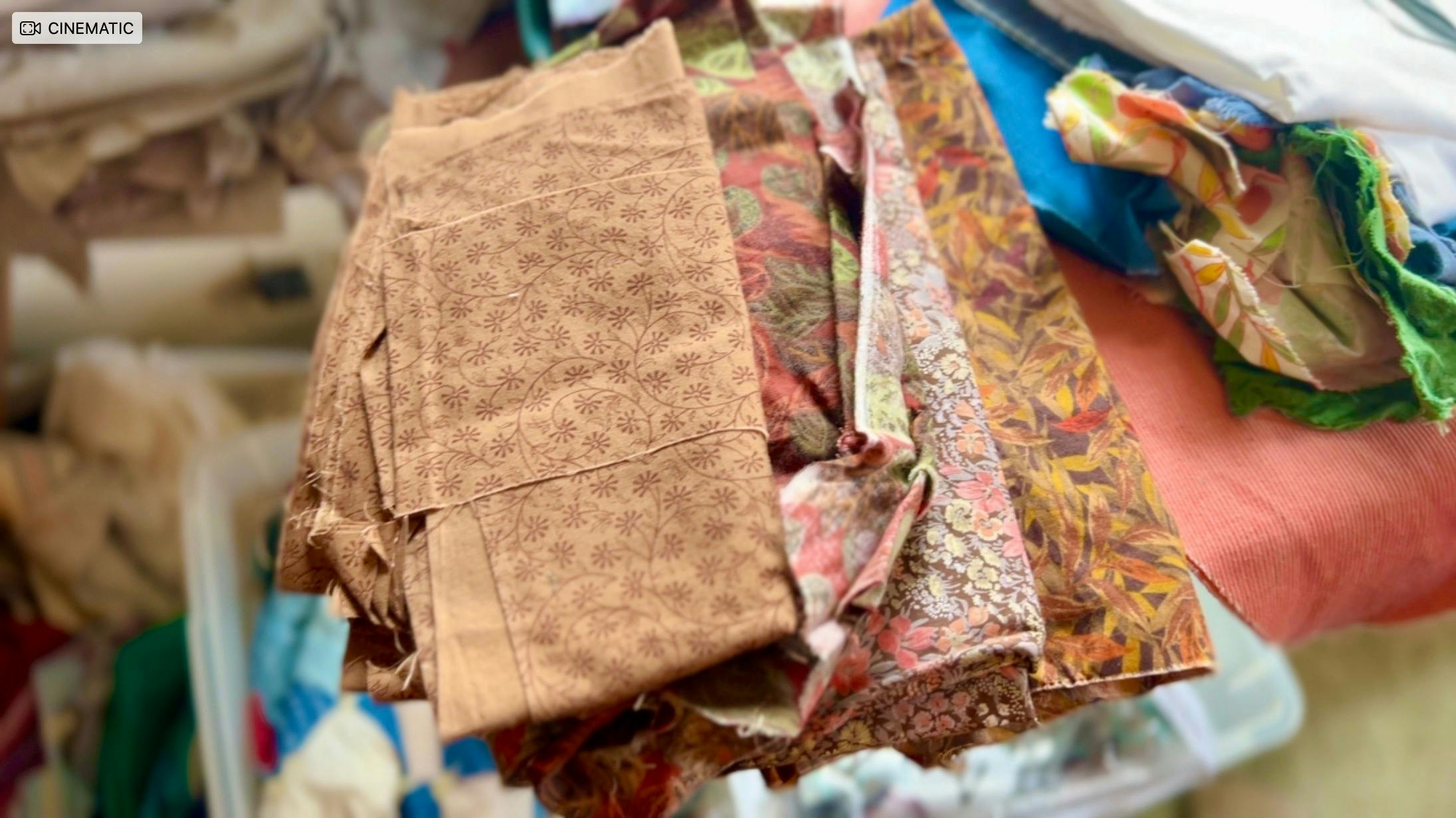 A pile of four kinds of brown fabric with floral patterns on them.