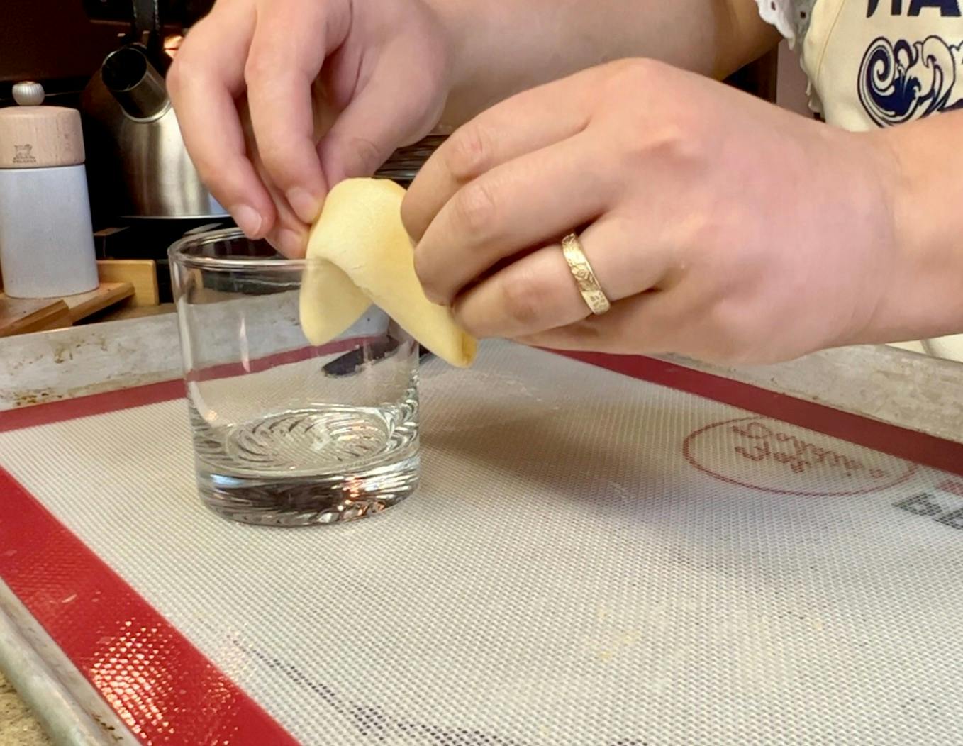 Folding a fortune cookie over the edge of a glass