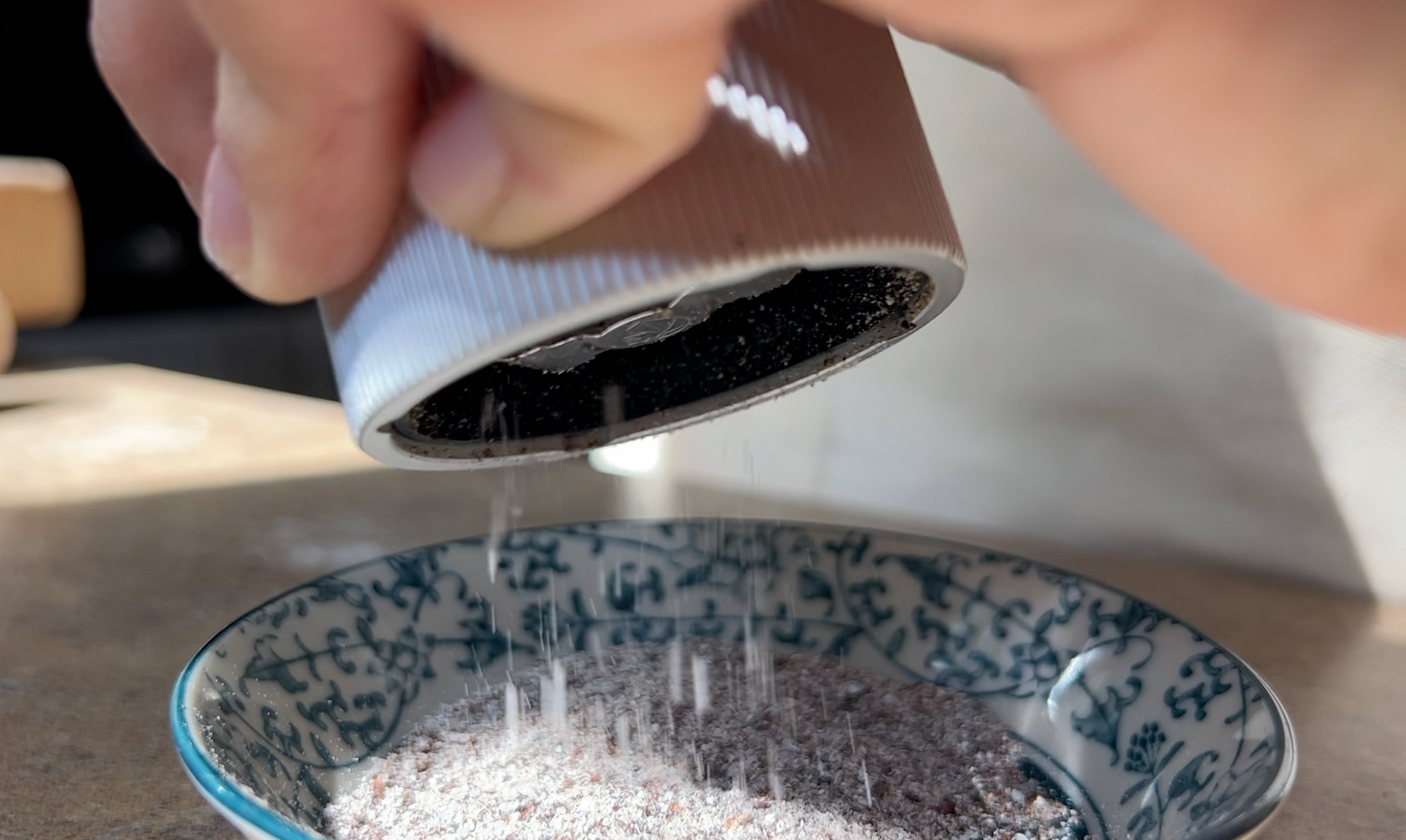 Grinding grains of paradise with a pepper mill