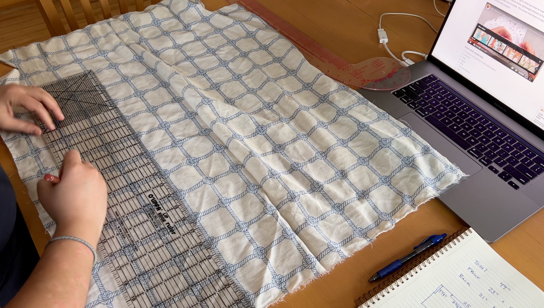 Measuring a piece of white fabric with a blue rope grid design.