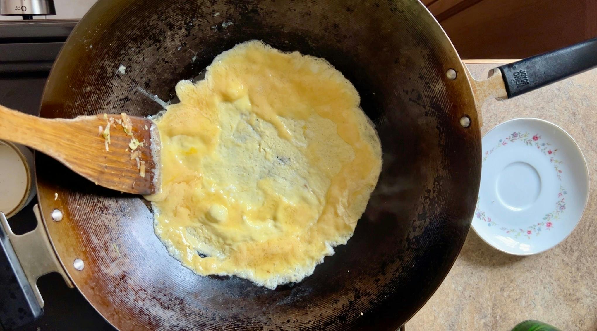 A thin omelette cooking in a wok.