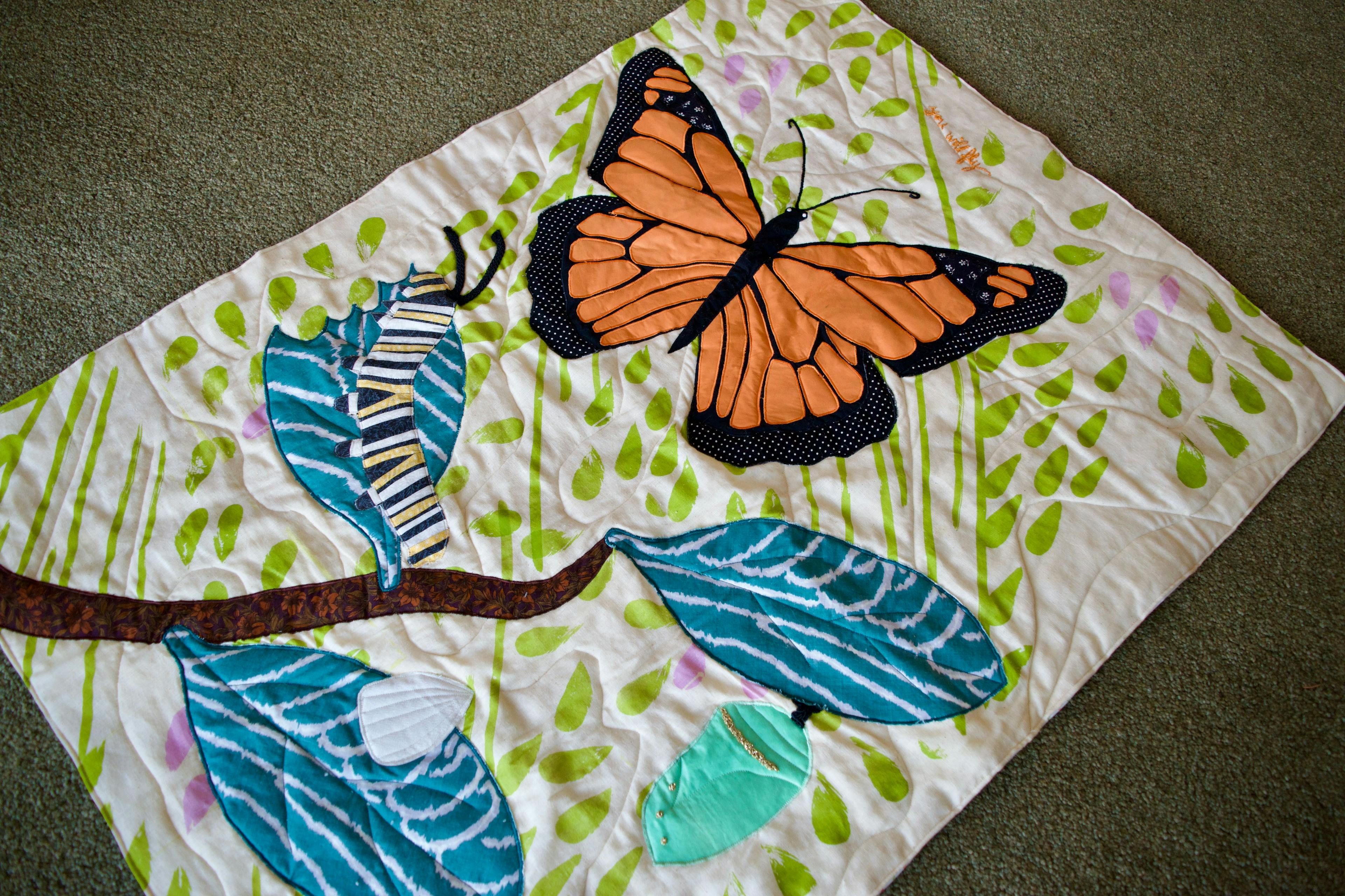 A quilt showing the life cycle of a butterfly
