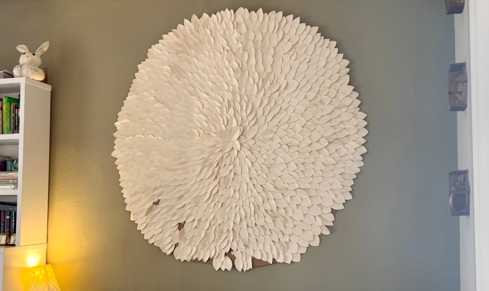 A large wall hanging of a multi-petaled flower made out of posterboard