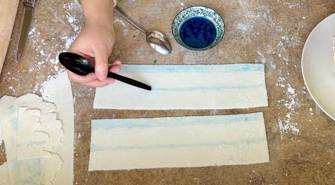 Painting blue stripes on the fondant.