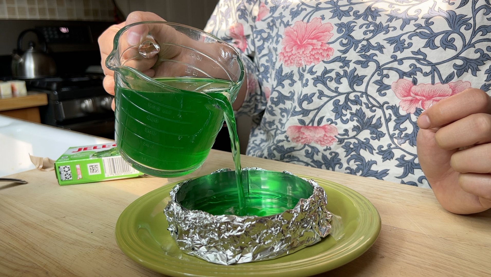 Pouring green jello into the makeshift mold.