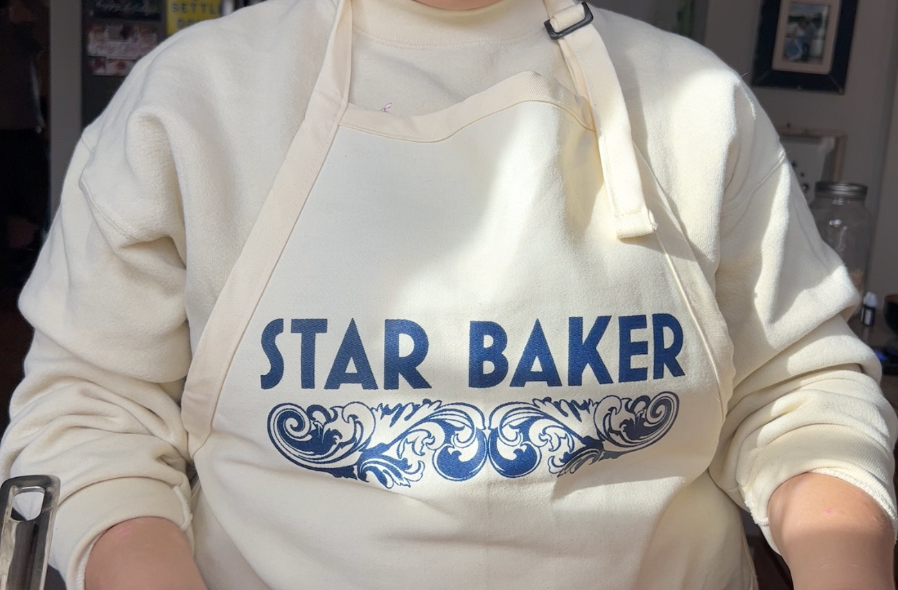 Katrina wearing an apron that says Star Baker across the chest.