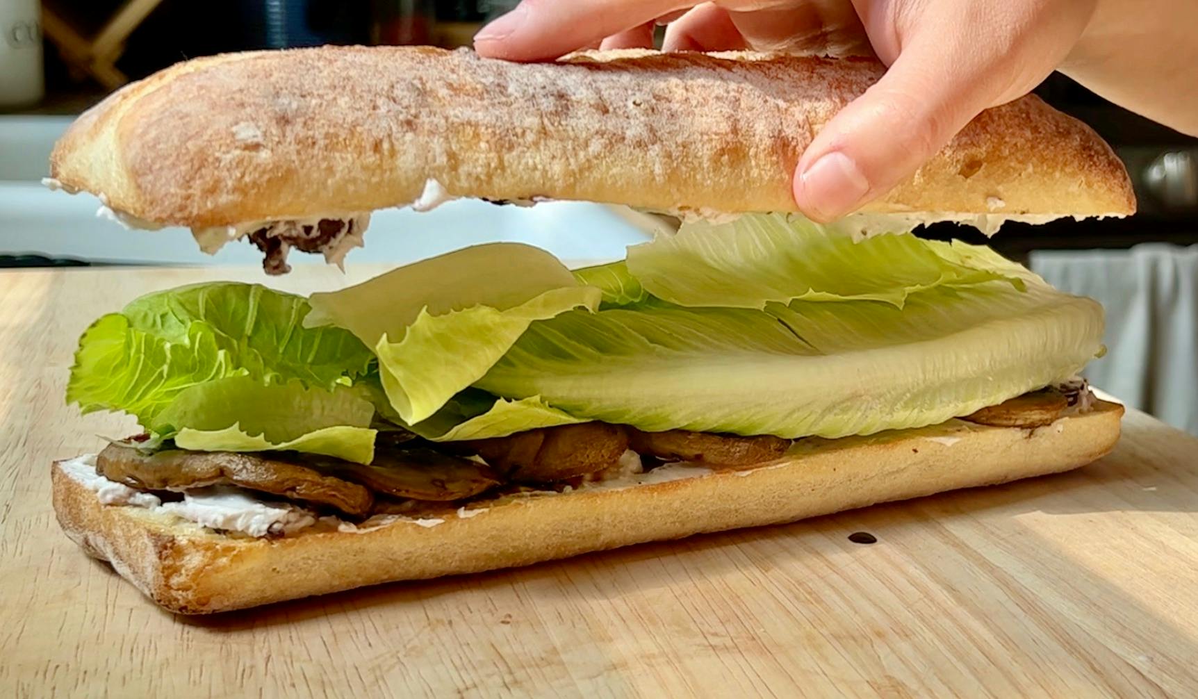 Placing the top piece of bread on top of the sandwich