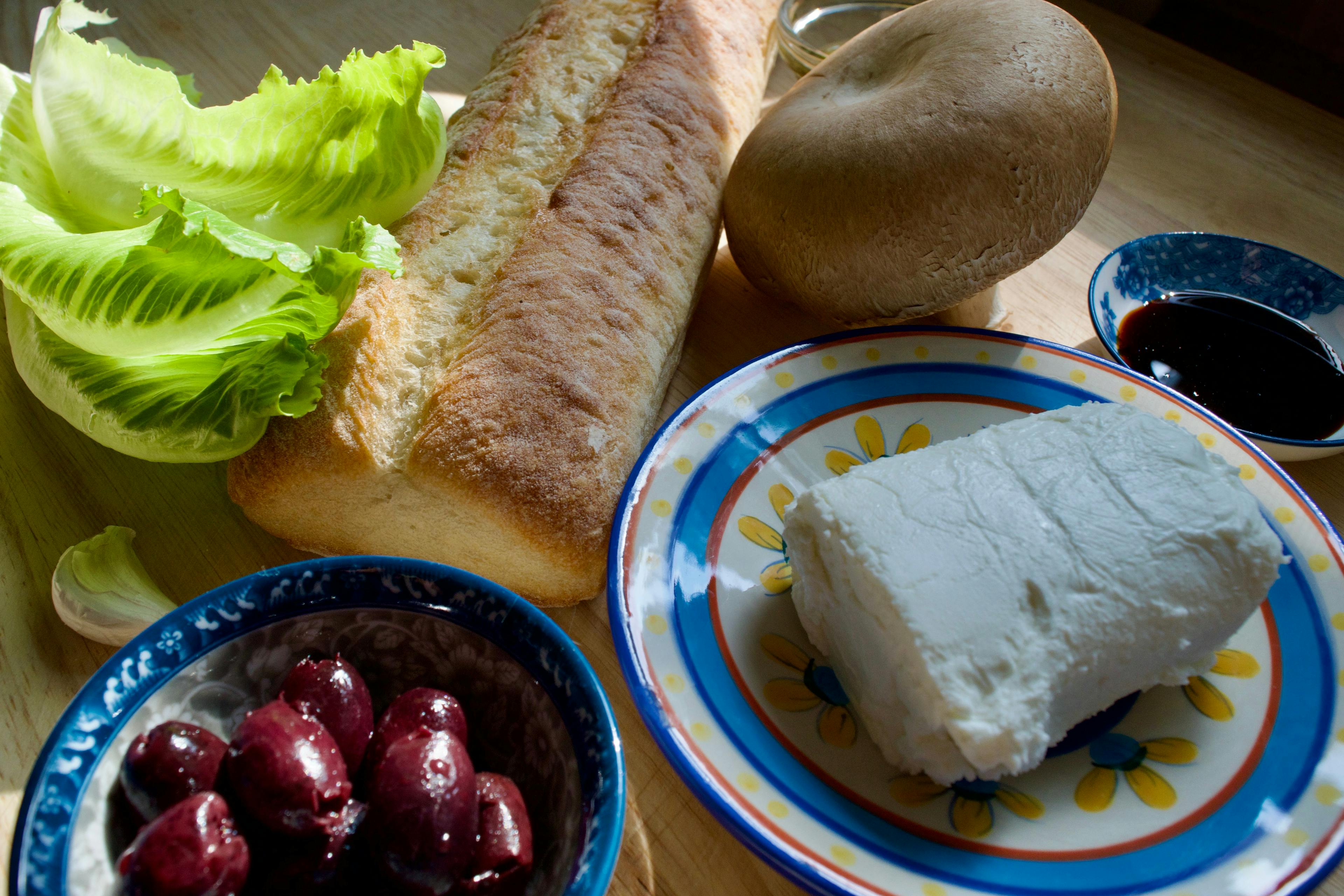 Ingredients ready to go - bread, lettuce, goat cheese, portobello mushroom, Kalamata olives, garlic, balsamic vinegar