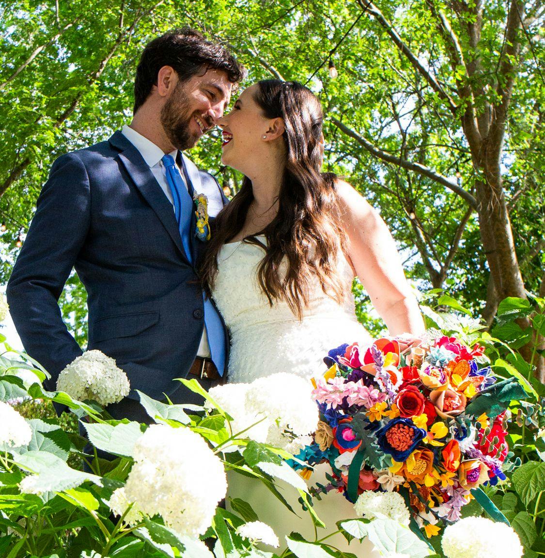 Lauren, holding her fabric bouquet, and her husband Jake, looking lovingly at each other in the sunshine.