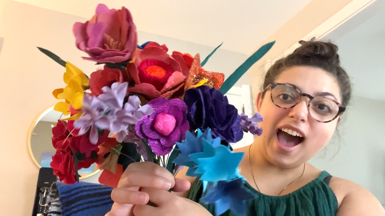 Holding a small bouquet of fabric flowers with an excited look on my face.