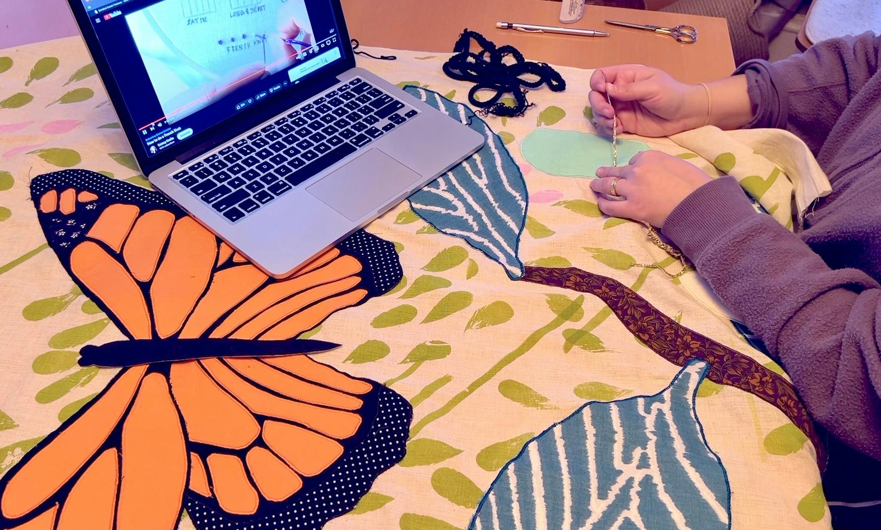 Embroidering with my laptop open with a French knot tutorial