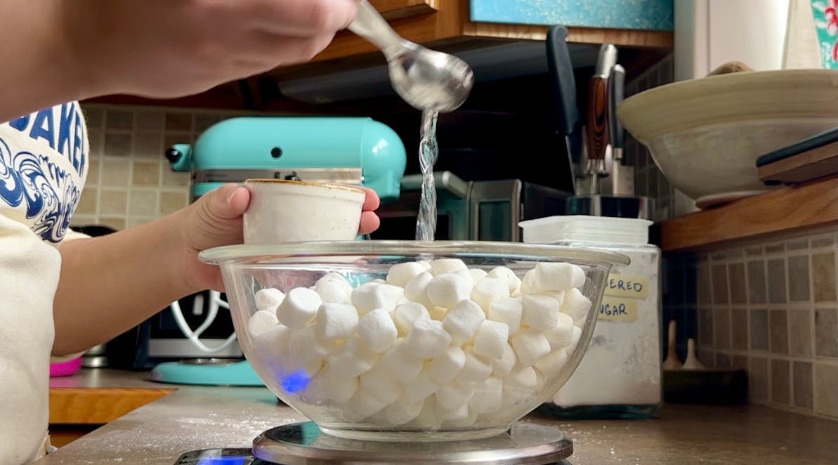 Bowl of marshmallows getting a drizzle of water.