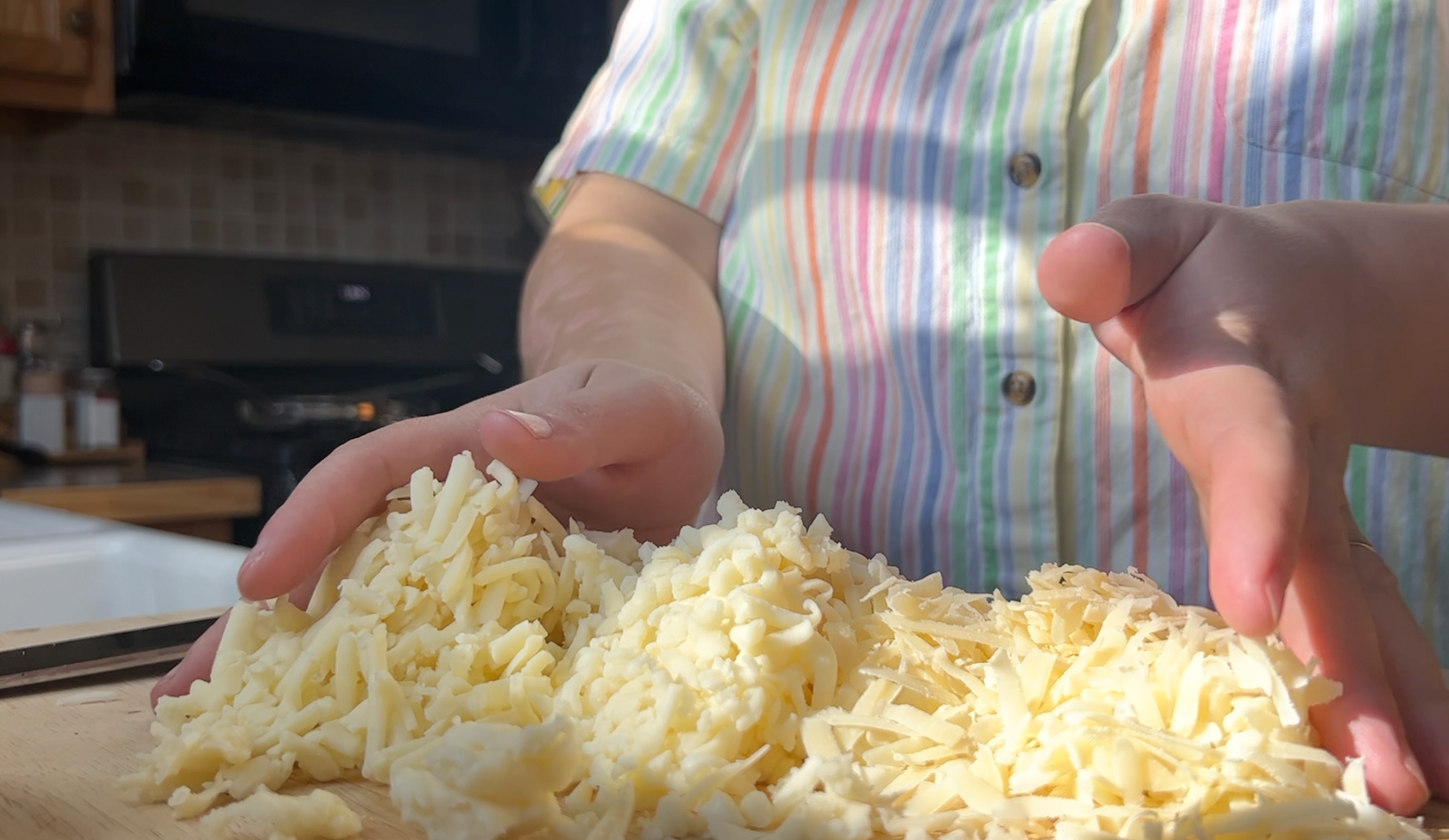 Three piles of grated cheese on a cutting board