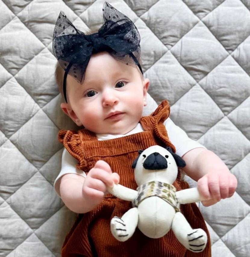 Baby Stella holding her tiny stuffed puppy, Brexley.