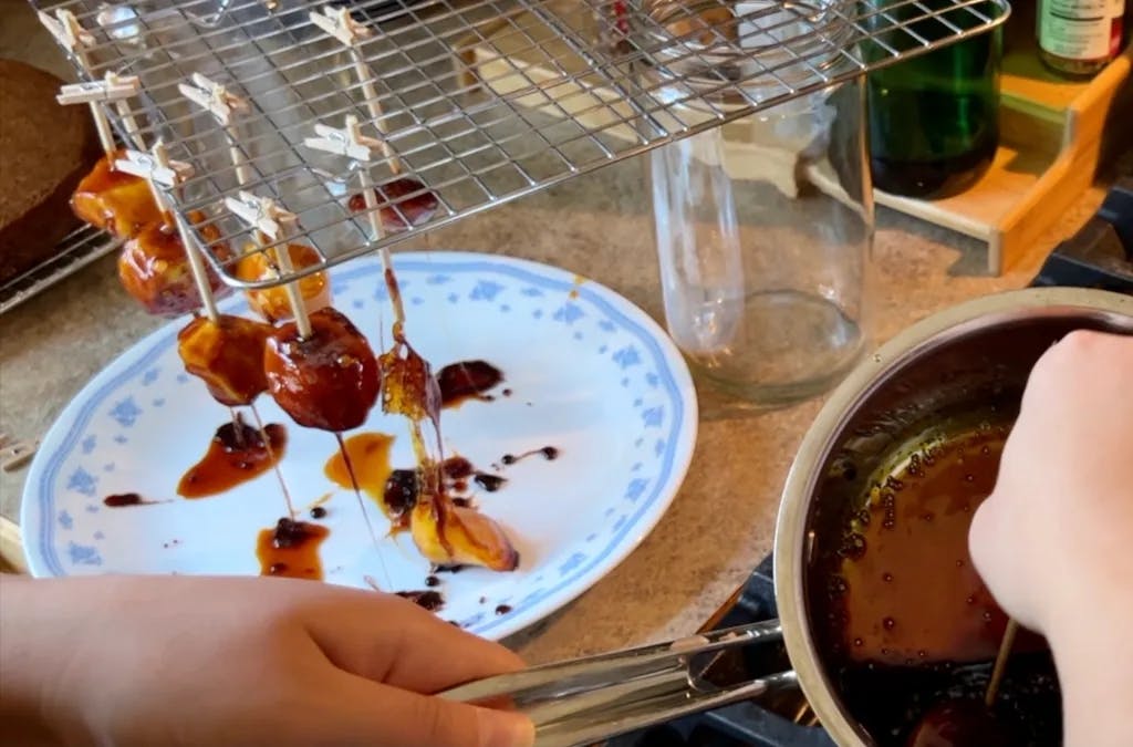 Burnt caramel dripping off of mini toffee apples.