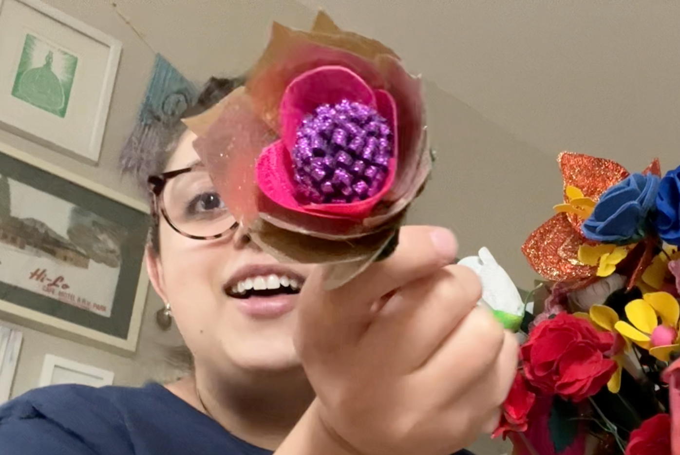 Holding a gold, purple, and pink flower